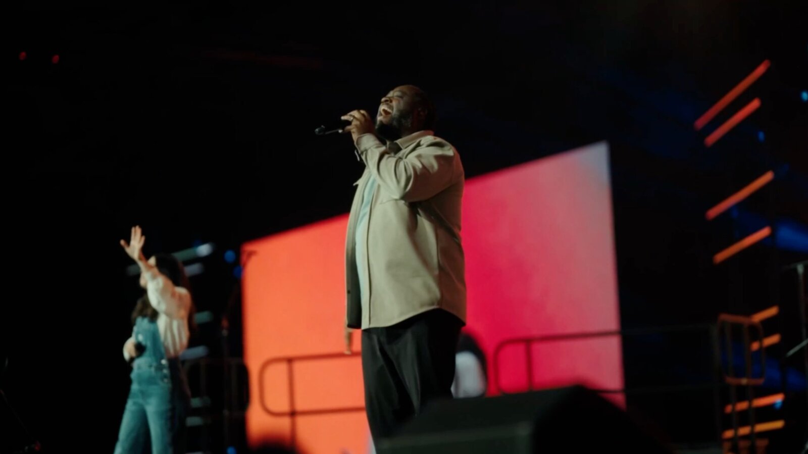Performer on stage with vivid color backdrop